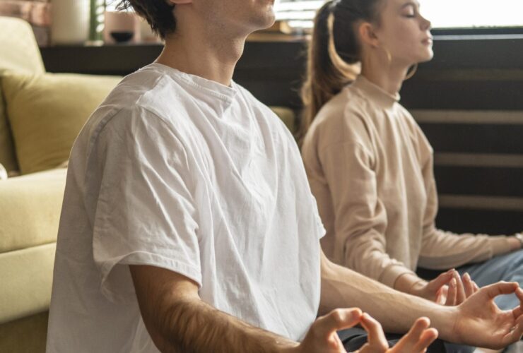 full shot couple meditating together scaled