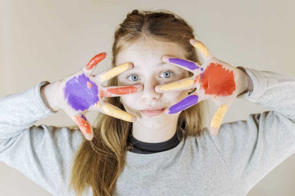 girl-with-painted-hands-looking-camera